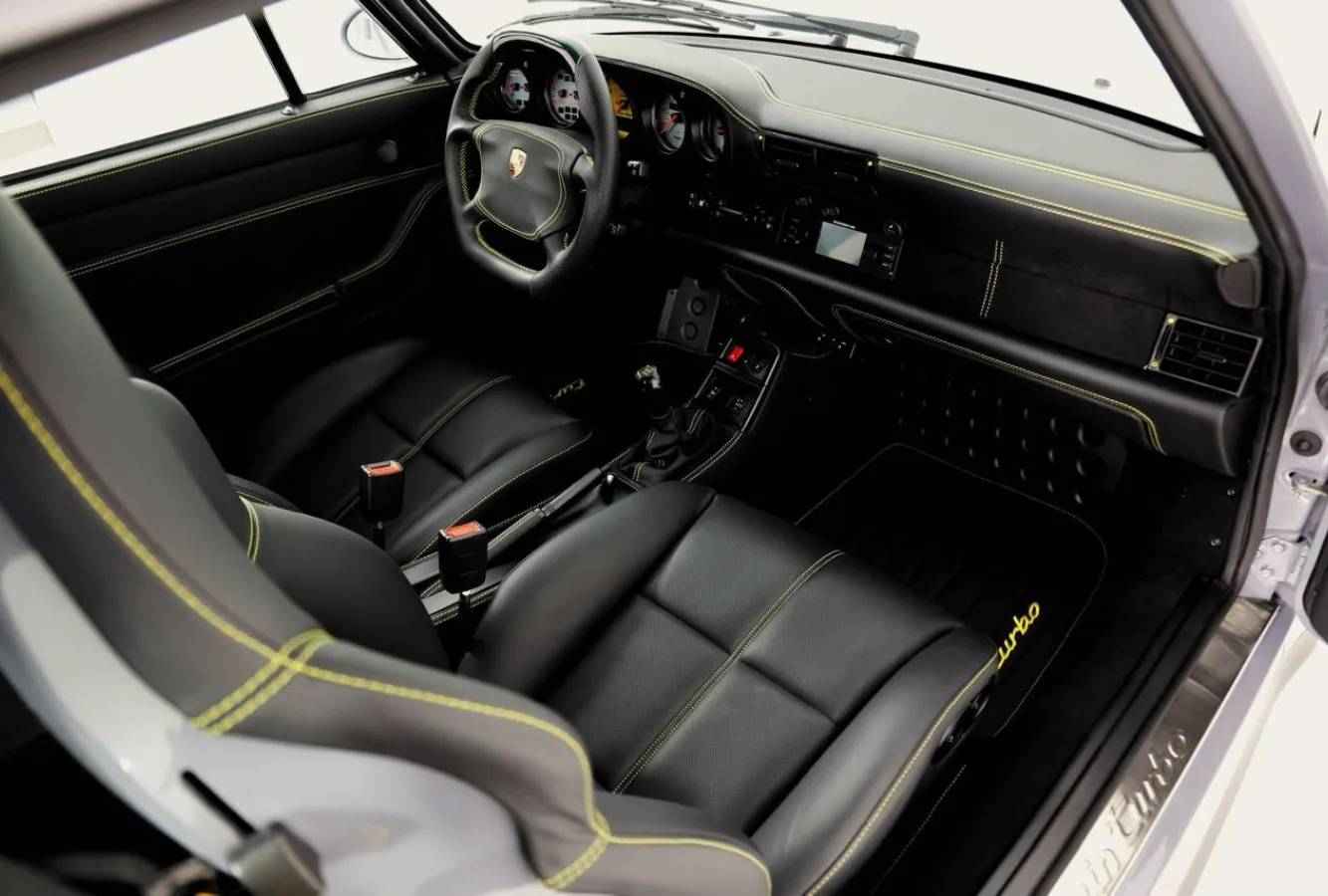 Luxury car upholstery with custom black leather and yellow stitching in a Porsche interior
